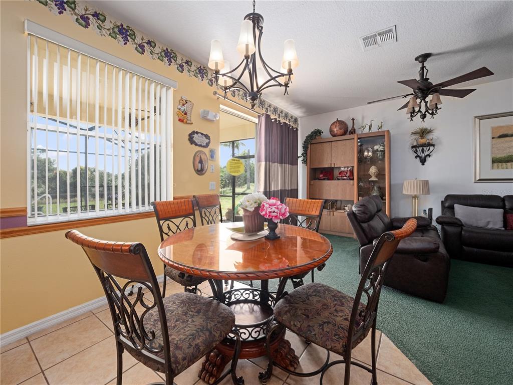 723 Wildflower Road Davenport, FL 33837 - Photo 11 of 34 a dining room with furniture a chandelier and window