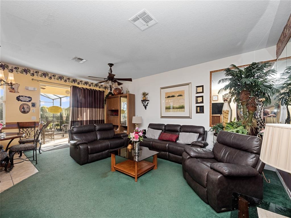 723 Wildflower Road Davenport, FL 33837 - Photo 12 of 34 a living room with furniture and a chandelier