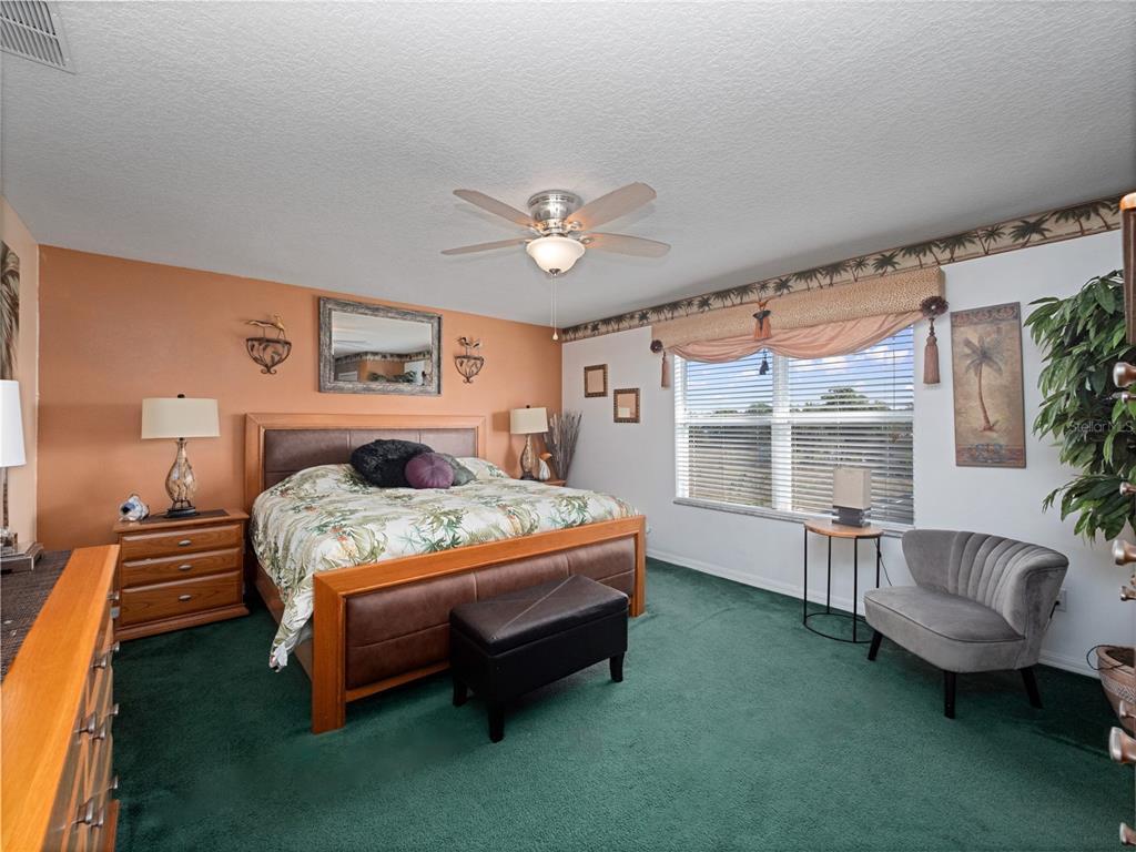 723 Wildflower Road Davenport, FL 33837 - Photo 14 of 34 a bedroom with a bed couch and a window