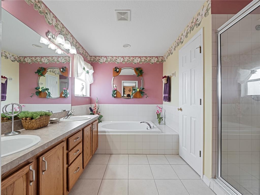 723 Wildflower Road Davenport, FL 33837 - Photo 15 of 34 a bathroom with a tub sink and mirror