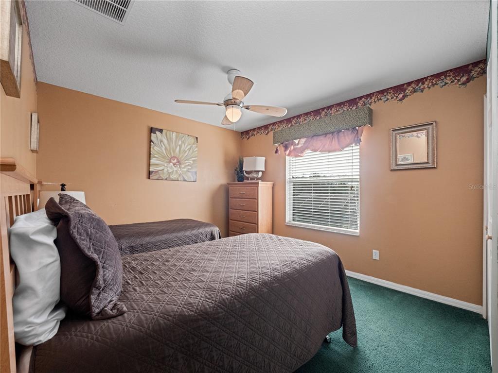 723 Wildflower Road Davenport, FL 33837 - Photo 19 of 34 a bedroom with a bed dresser and a window