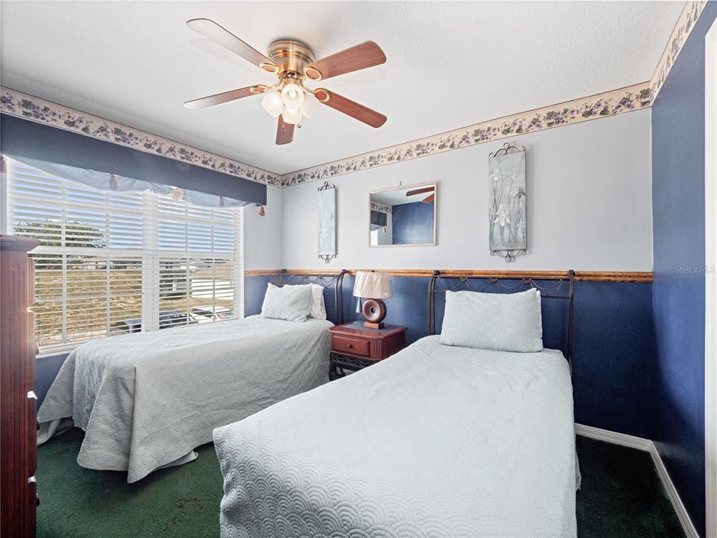 723 Wildflower Road Davenport, FL 33837 - Photo 23 of 34 a bedroom with two beds and a chandelier