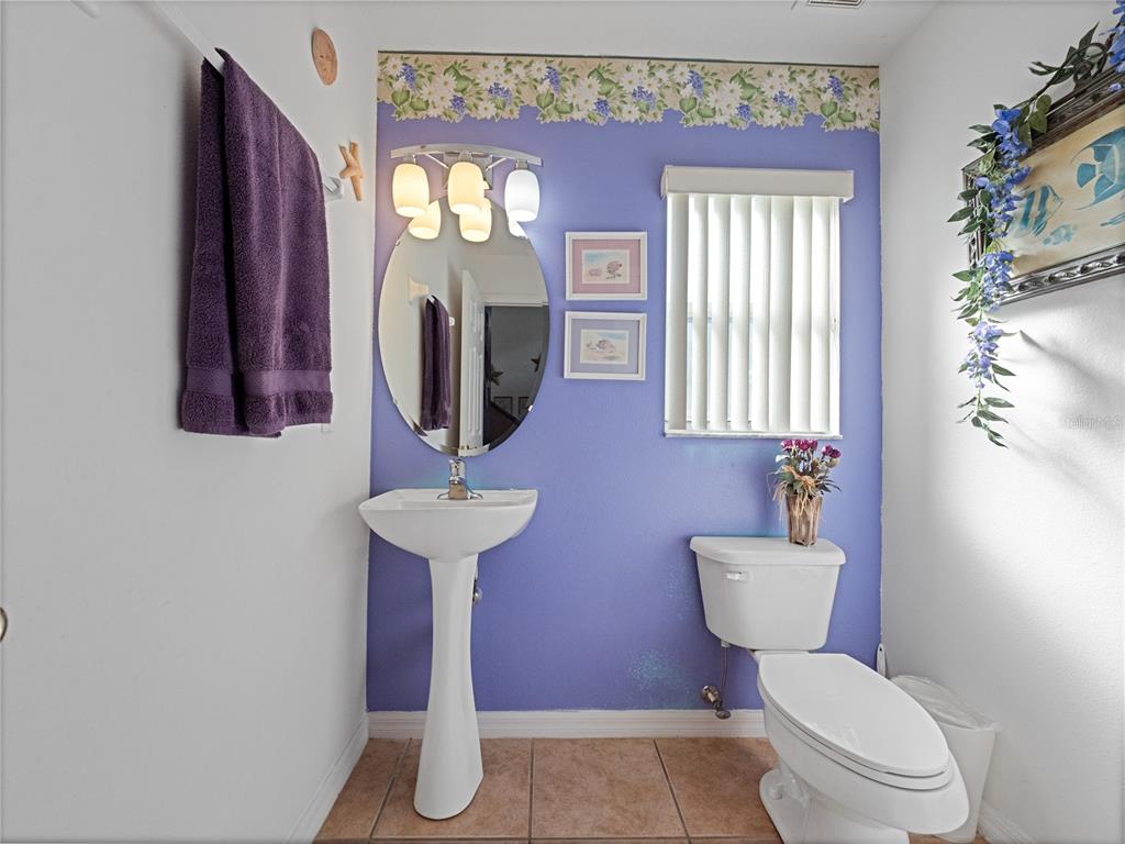 723 Wildflower Road Davenport, FL 33837 - Photo 24 of 34 a bathroom with a toilet sink and mirror