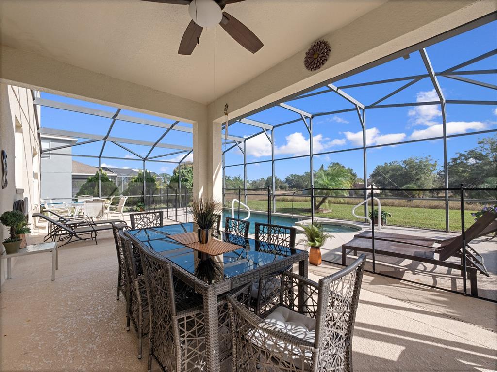 723 Wildflower Road Davenport, FL 33837 - Photo 28 of 34 a view of a patio with a table chairs and a backyard