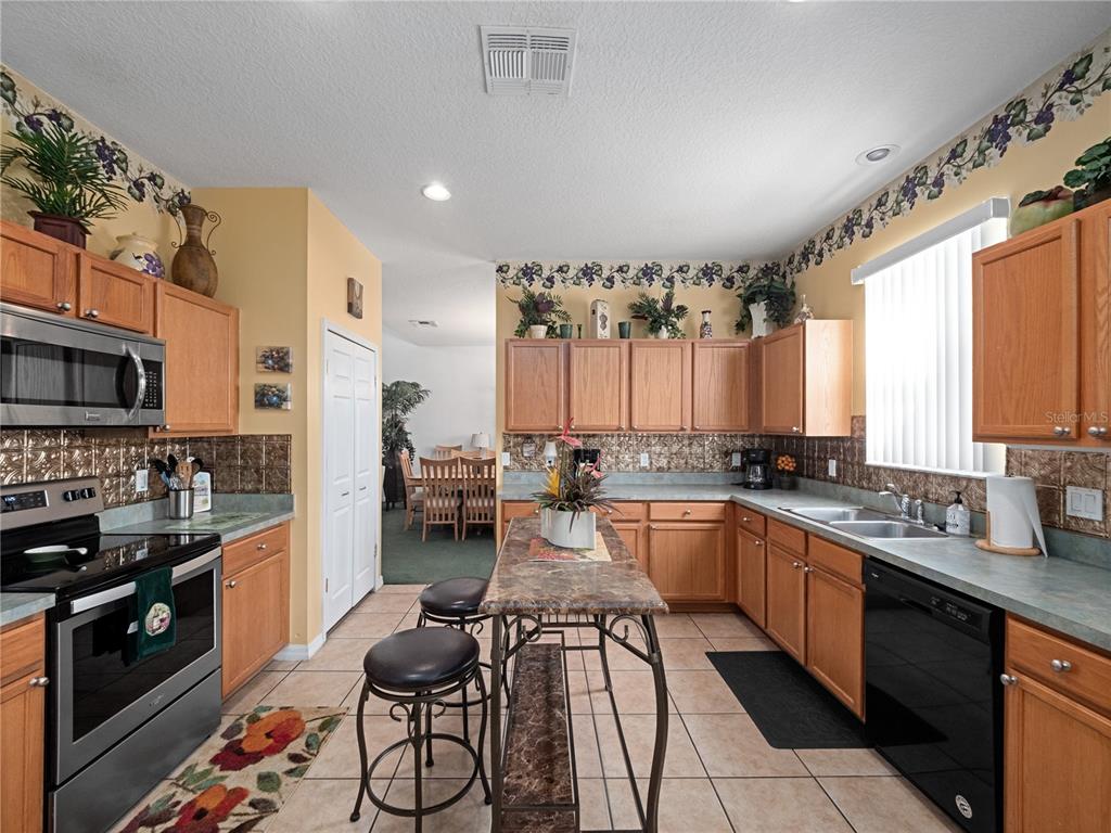 723 Wildflower Road Davenport, FL 33837 - Photo 9 of 34 a kitchen with lots of counter top space and stainless steel appliances