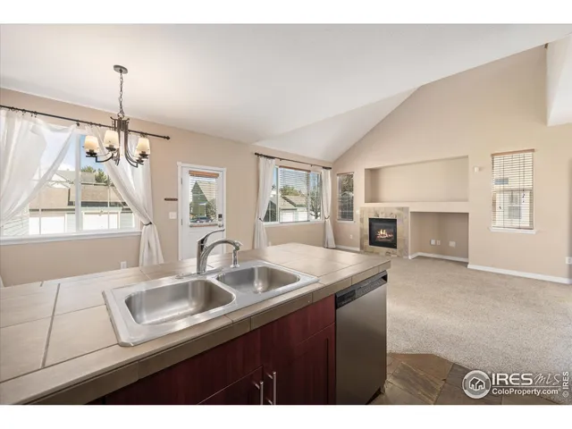 a kitchen that has a sink a window and chairs