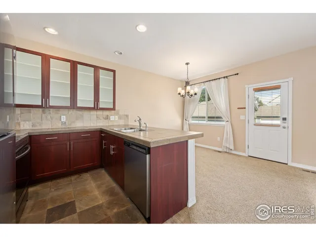 a kitchen with kitchen island granite countertop a sink cabinets and stainless steel appliances