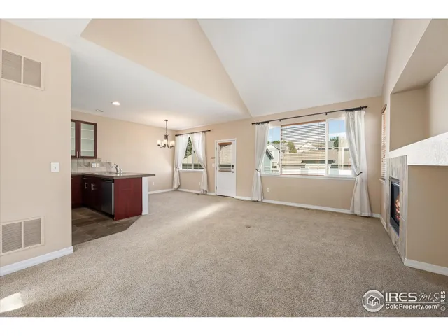 a living room with stainless steel appliances kitchen island granite countertop a refrigerator and cabinets
