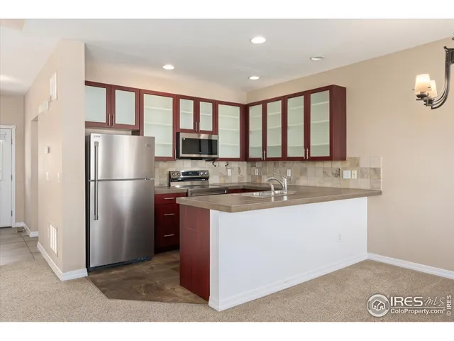 a kitchen with stainless steel appliances granite countertop a refrigerator a sink a stove a microwave and island