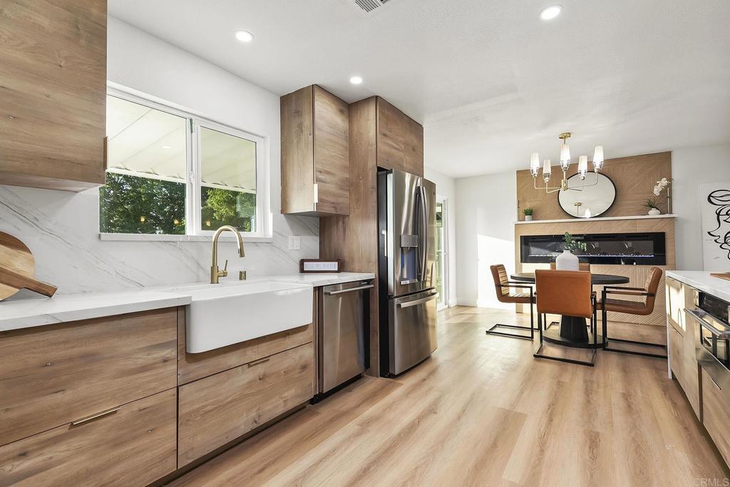 6802 Maury Drive San Diego, CA 92119 - Photo 1 of 44 a kitchen with stainless steel appliances a stove a sink dishwasher a refrigerator and a dining table with wooden floor