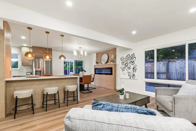 a living room with fireplace furniture and a large window