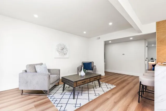a living room with furniture and a wooden floor