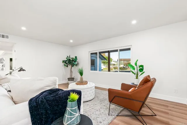 a living room with furniture a window and a potted plant
