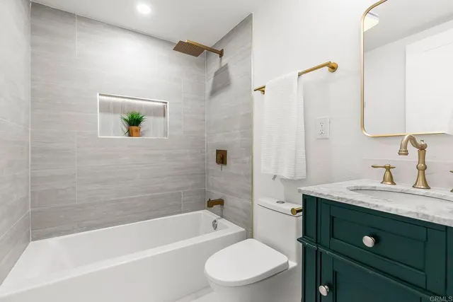 a bathroom with a granite countertop sink a toilet and shower