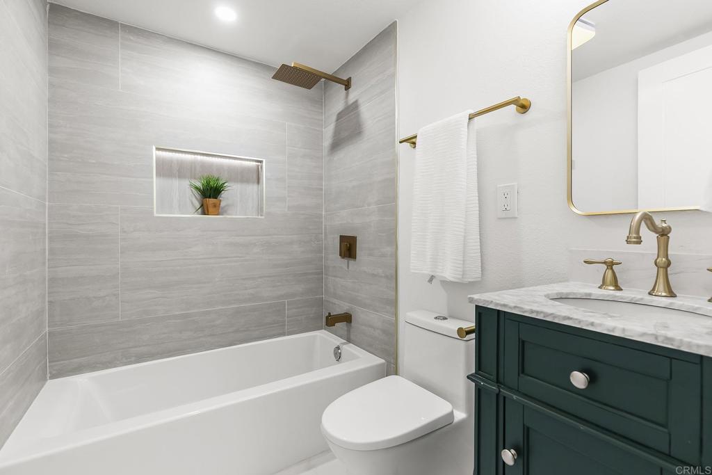 6802 Maury Drive San Diego, CA 92119 - Photo 19 of 44 a bathroom with a granite countertop sink a toilet and shower