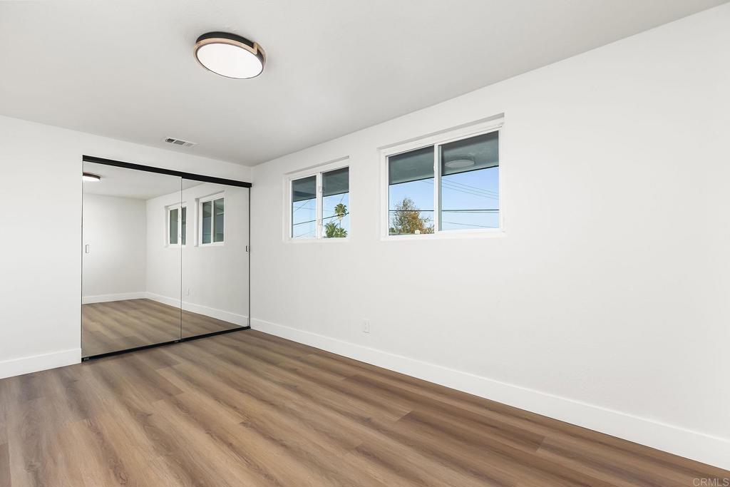 6802 Maury Drive San Diego, CA 92119 - Photo 21 of 44 an empty room with wooden floor and windows