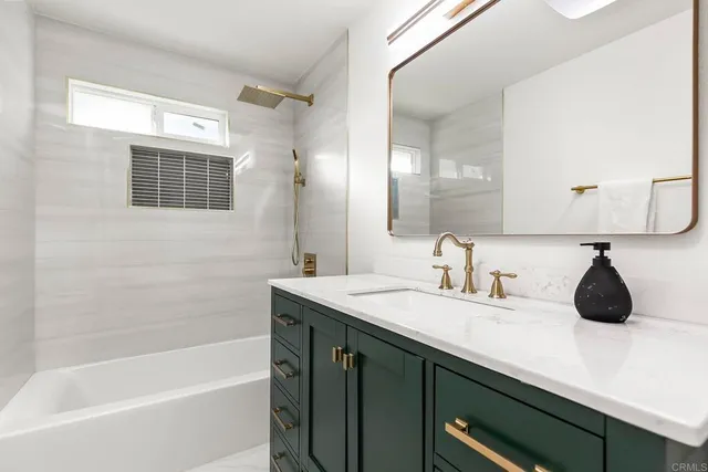 a bathroom with a tub a sink and a mirror