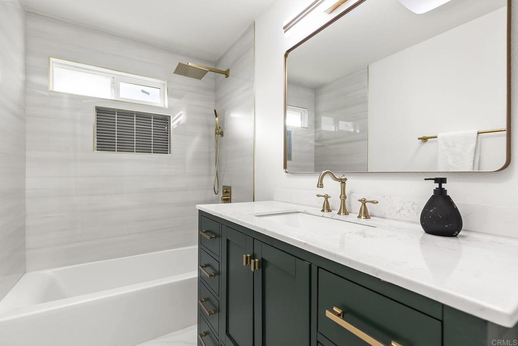 6802 Maury Drive San Diego, CA 92119 - Photo 23 of 44 a bathroom with a tub a sink and a mirror