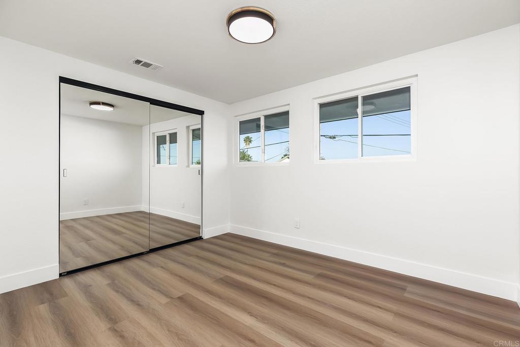 6802 Maury Drive San Diego, CA 92119 - Photo 24 of 44 an empty room with wooden floor and windows