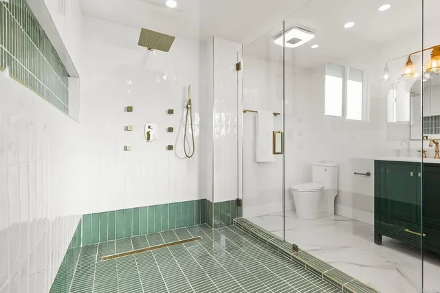 a bathroom with a sink a toilet and shower