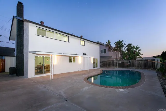 a view of a house with backyard and sitting area