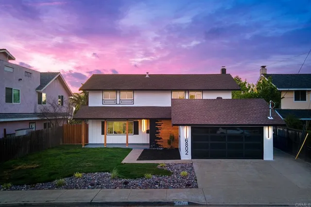 a front view of a house with a garden and yard