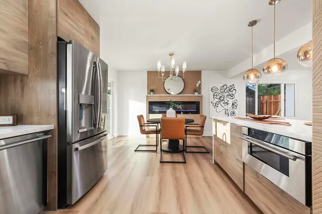 a kitchen with stainless steel appliances a stove top oven a refrigerator and furniture