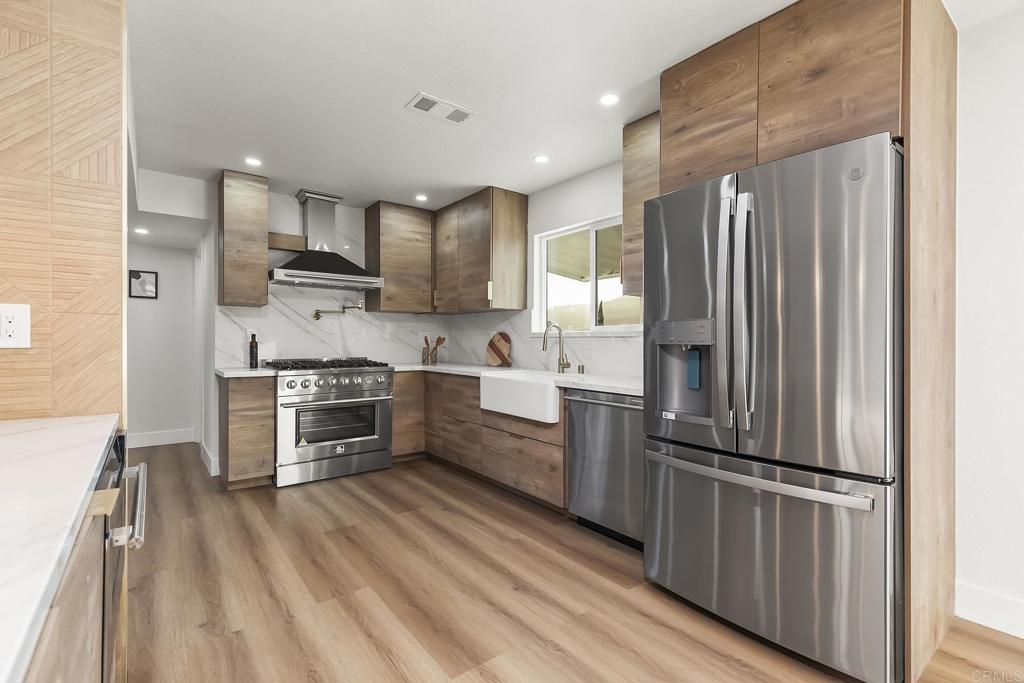 6802 Maury Drive San Diego, CA 92119 - Photo 7 of 44 a kitchen with stainless steel appliances a refrigerator sink and cabinets
