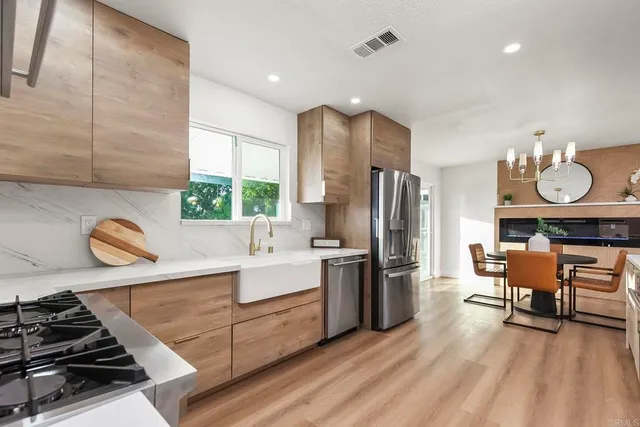 a kitchen with stainless steel appliances granite countertop a stove refrigerator and cabinets