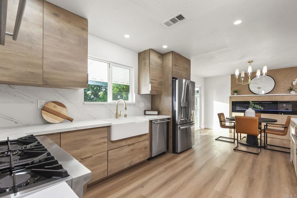 6802 Maury Drive San Diego, CA 92119 - Photo 8 of 44 a kitchen with stainless steel appliances granite countertop a stove refrigerator and cabinets