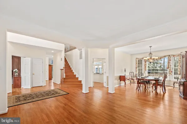 a kitchen with stainless steel appliances granite countertop hardwood floor sink stove dining table and chairs