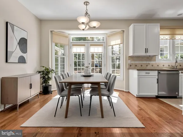 a kitchen with stainless steel appliances granite countertop a stove top oven a sink a refrigerator and white cabinets