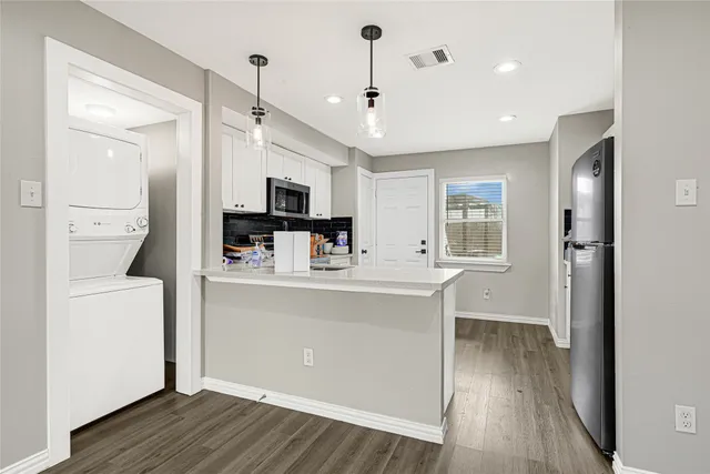 a view of a kitchen with wooden floor and a ceiling fan