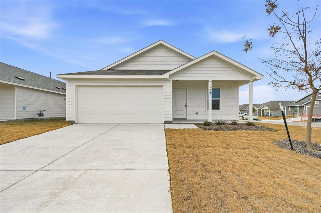 a view of a white house with a yard and large tree