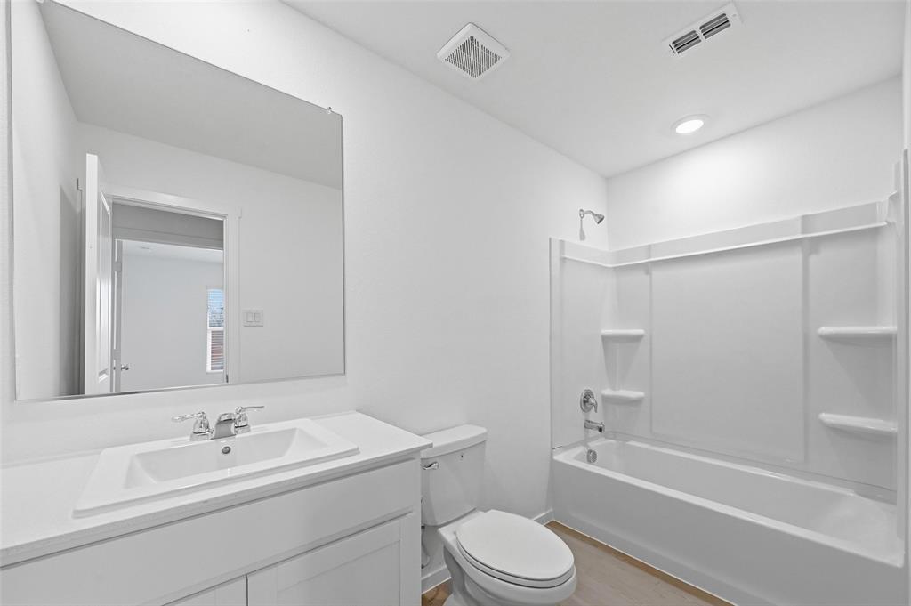 7709 Rutherford Lane McKinney, TX 75071 - Photo 17 of 23 a bathroom with a bathtub shower sink vanity mirror and toilet