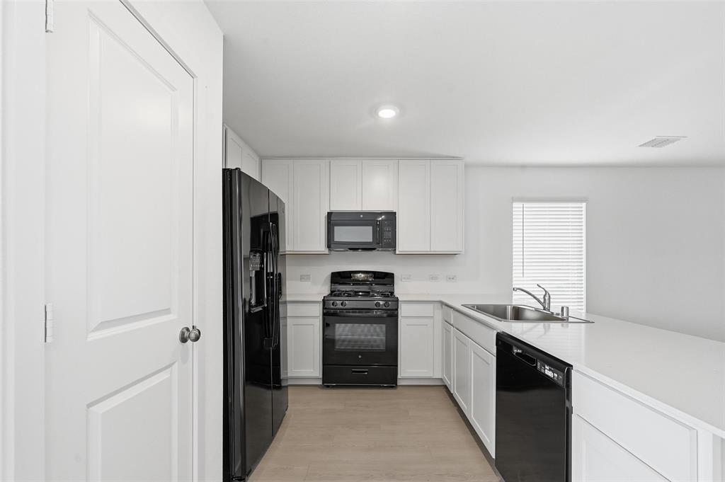7709 Rutherford Lane McKinney, TX 75071 - Photo 6 of 23 a kitchen with a refrigerator stove and oven