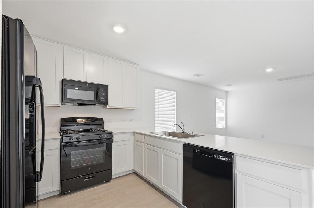 7709 Rutherford Lane McKinney, TX 75071 - Photo 7 of 23 a kitchen with a sink stainless steel appliances and cabinets