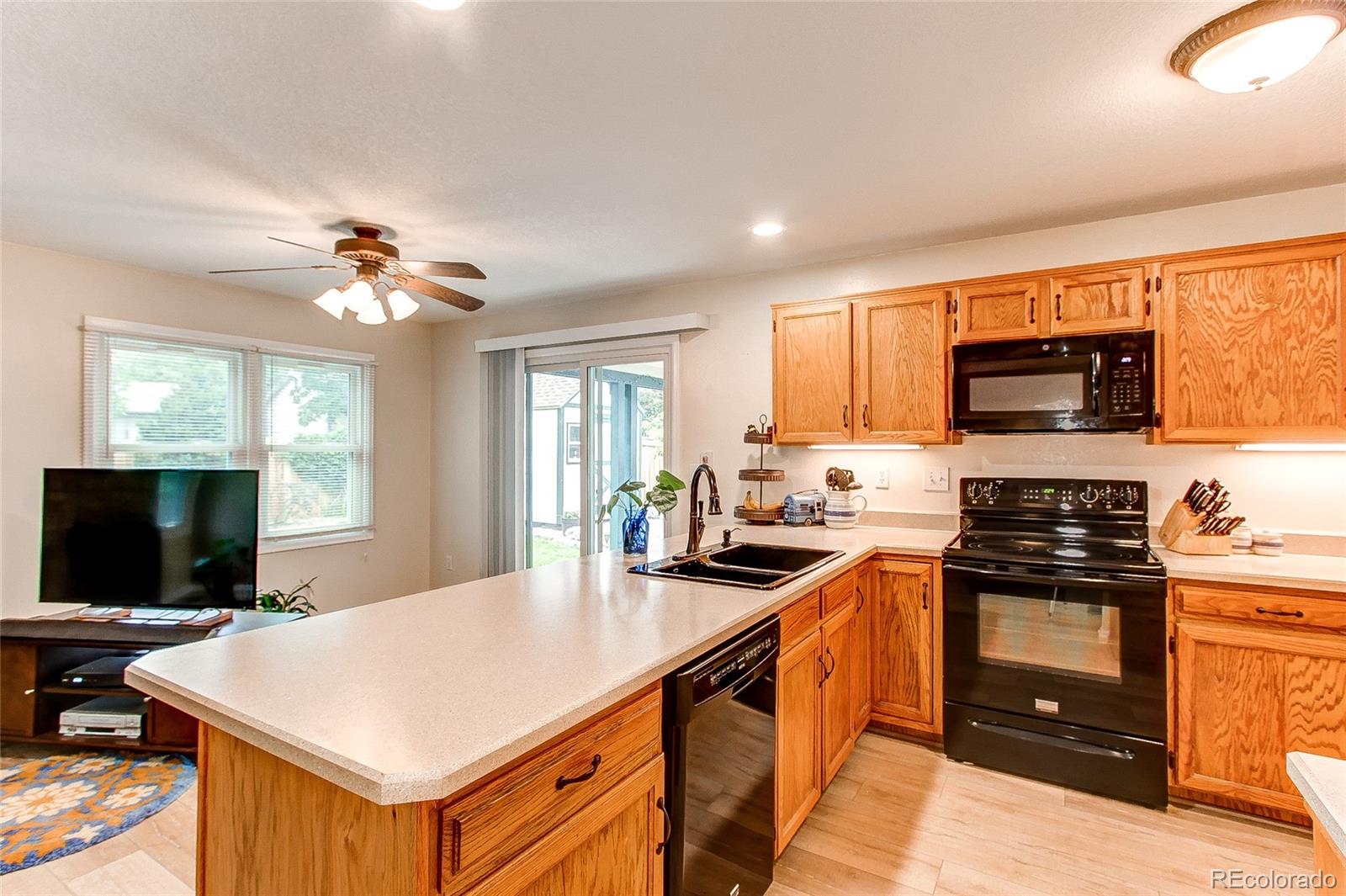 19231 East Rice Drive Aurora, CO 80015 - Photo 11 of 40 a kitchen with a stove a sink and a microwave