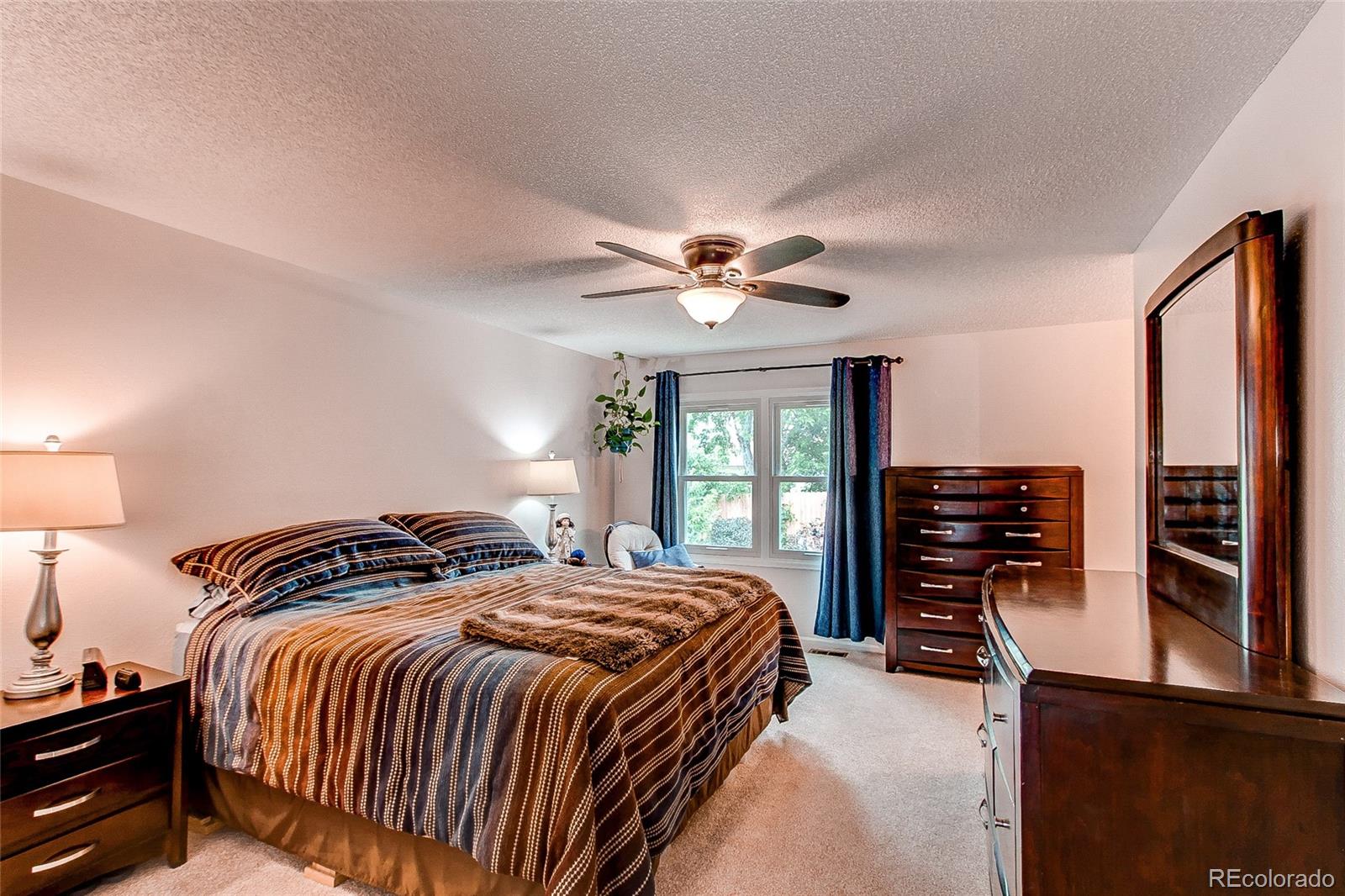 19231 East Rice Drive Aurora, CO 80015 - Photo 13 of 40 a bedroom with a bed and dresser with window