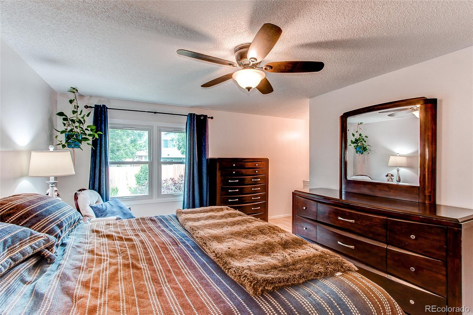 19231 East Rice Drive Aurora, CO 80015 - Photo 14 of 40 a bedroom with a bed and a dresser next to a window