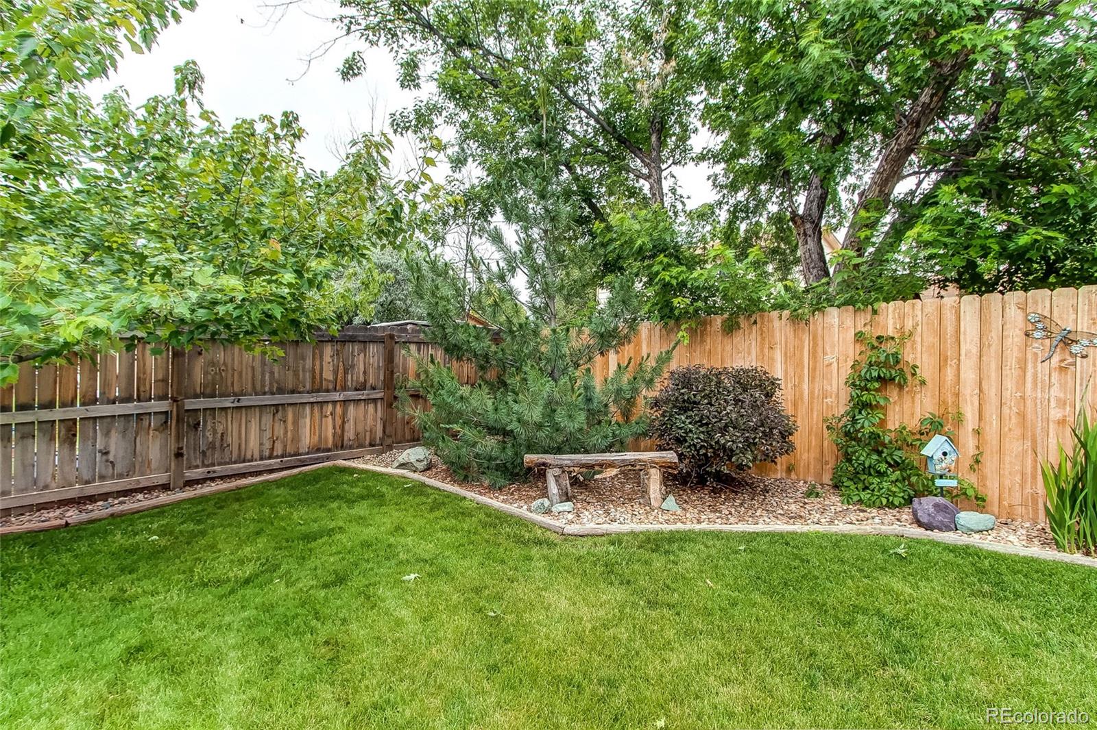 19231 East Rice Drive Aurora, CO 80015 - Photo 35 of 40 a view of a backyard with large trees and wooden fence