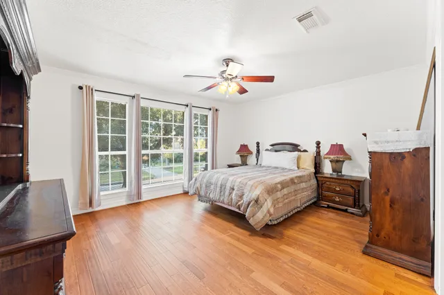 a bedroom with a bed dresser and a window
