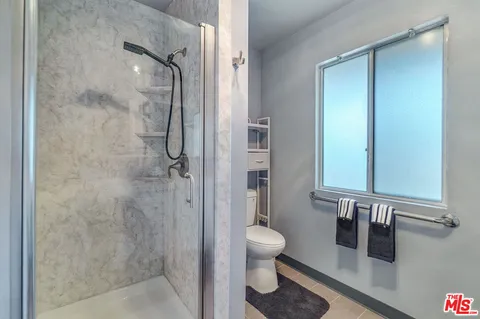 a bathroom with a toilet and a shower