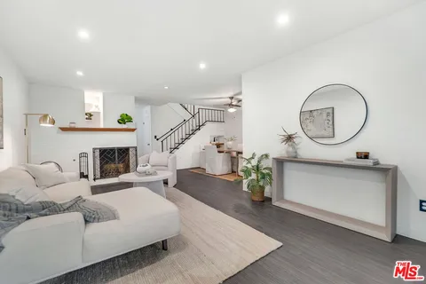 a living room with furniture a fireplace and a view of kitchen