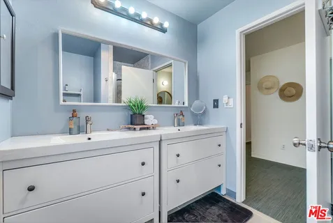 a bathroom with a double vanity sink mirror and