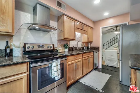 a kitchen with stainless steel appliances granite countertop a stove a sink and a microwave