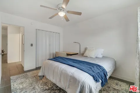 a bedroom with a large bed and a chandelier