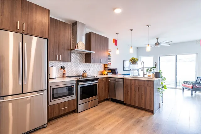 a kitchen with stainless steel appliances a refrigerator sink and cabinets