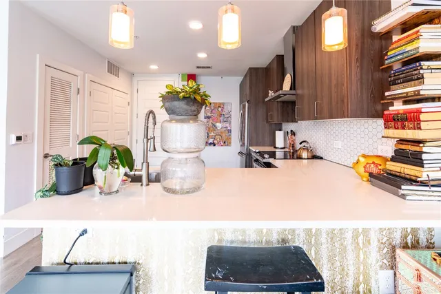 a bathroom with a sink a faucet a potted plant and a mirror