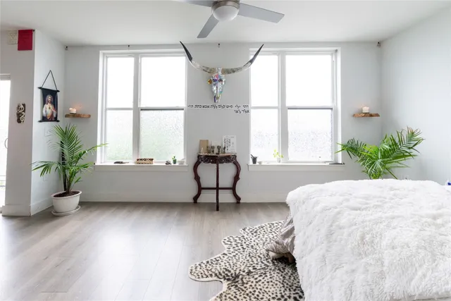 a bedroom with a bed and a large window